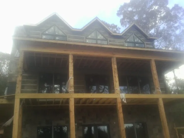 Dormers and porch framing on a large log home under construction — Roof Coating work by our crew in Stroudsburg
