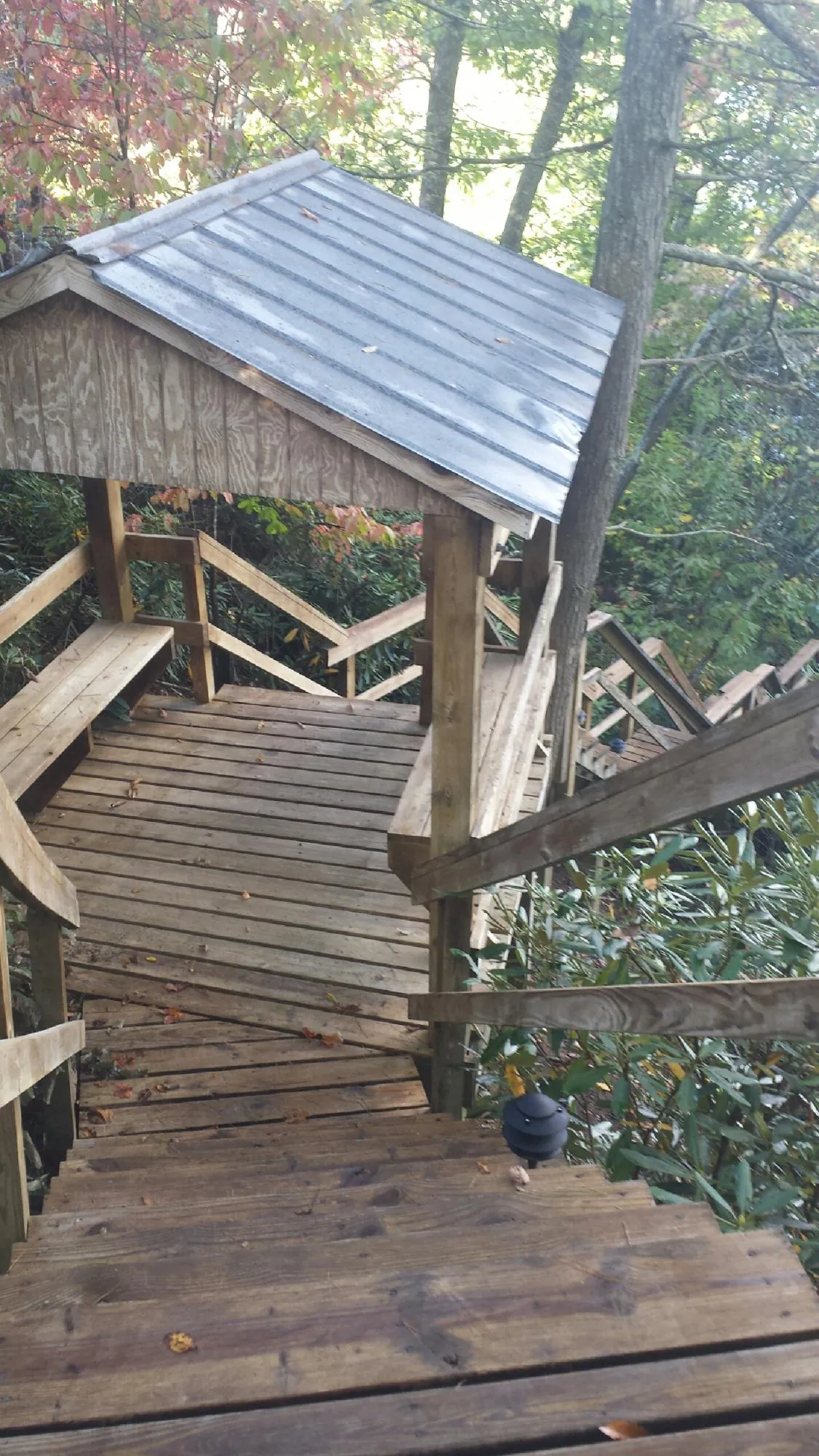 Metal roofed shelter over wooden steps on a wooded walkway — Skylight Repair & Installation work by our crew in Stroudsburg