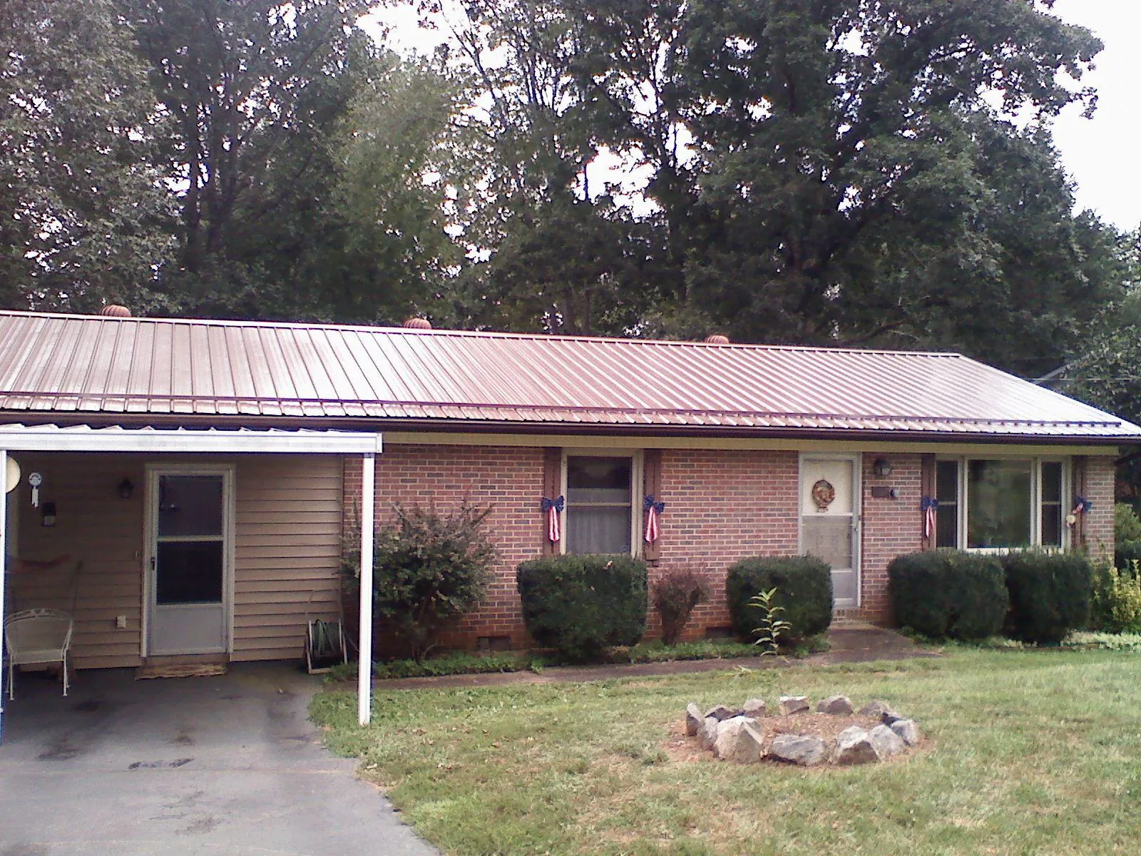 Bronze metal roof and carport on a brick ranch home — Roof Repair work by our crew in Stroudsburg